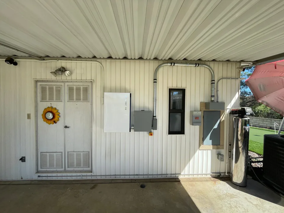 A Franklin control unit and electrical equipment installed on the wall of a covered patio.