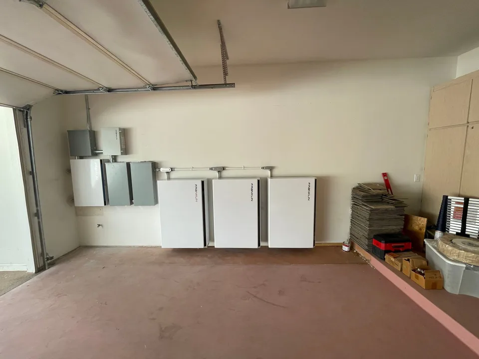 Three Franklin batteries mounted in a row along a garage wall.