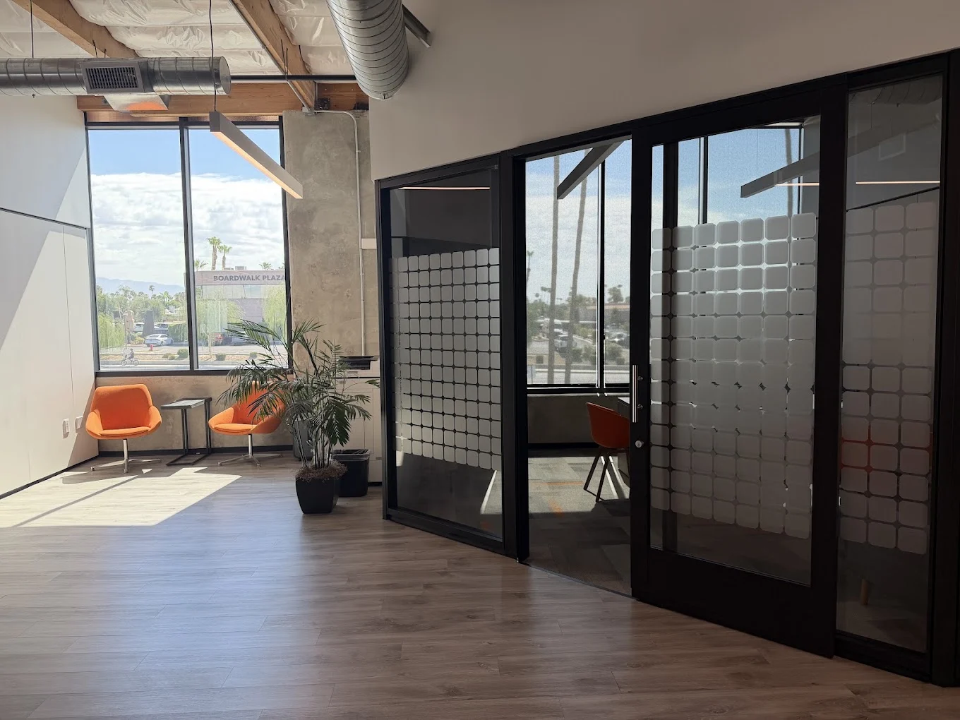 Glass-walled meeting rooms and a bright consultation area inside the Mycrogrid® Palm Desert office