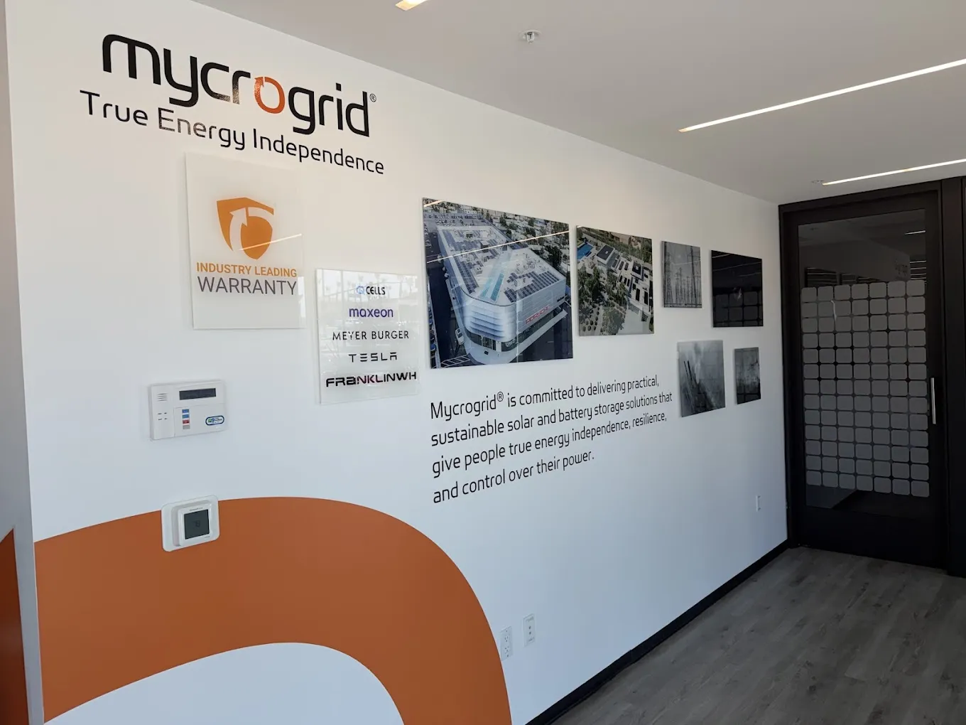 Mycrogrid® office brand wall showing partner brands and the industry-leading warranty