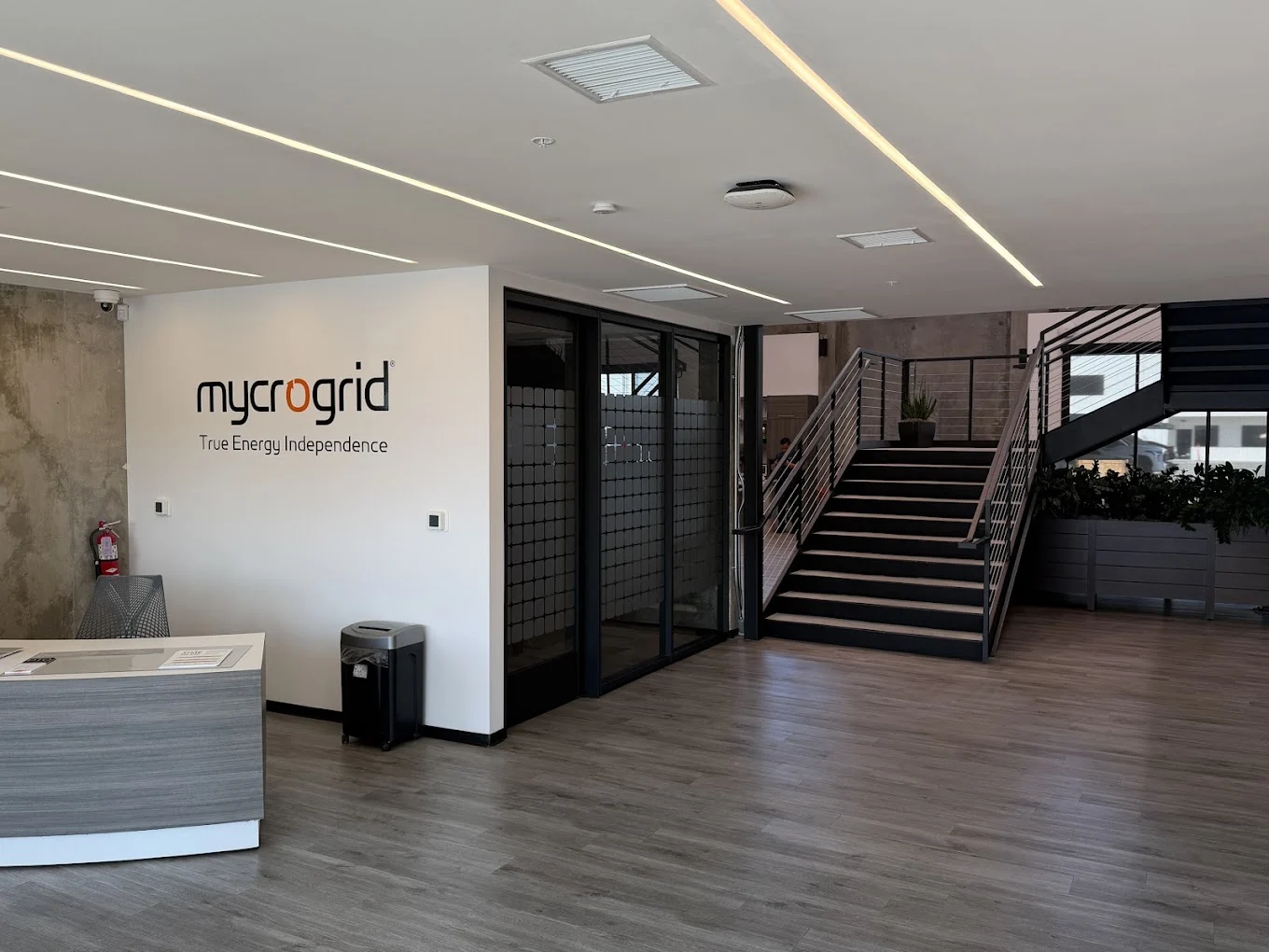 Mycrogrid reception area with the company logo, front desk, and staircase in the Palm Desert office